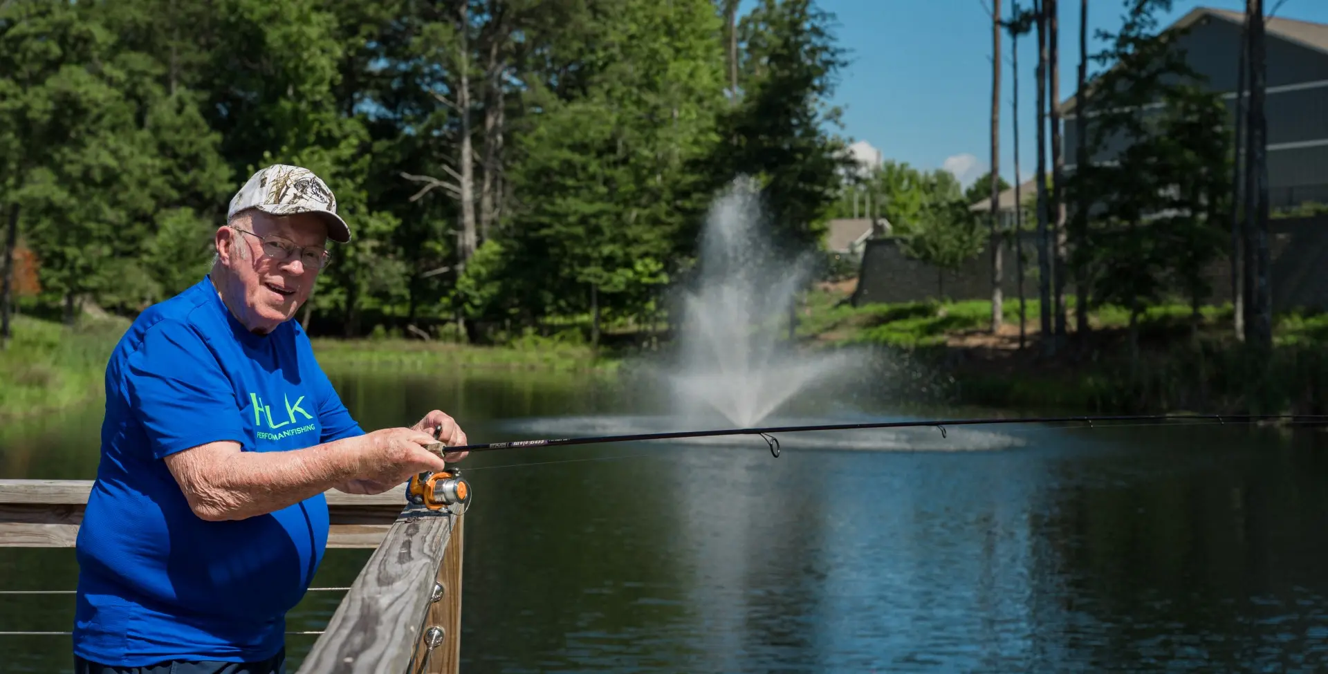 Manor Lake resident smiling by the lake and fountain